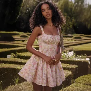 Beautiful detail of floral corset mini dress with lace-up front worn in a lush garden