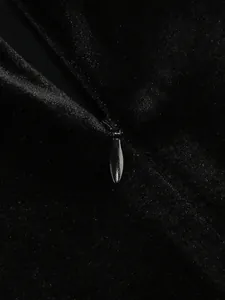 Gros plan détaillé sur la fermeture éclair invisible d'une robe de soirée en velours noir.