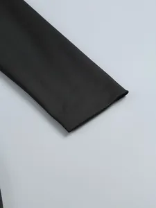 Macro view showing the smooth texture and stitching of the black long sleeve cuff detail