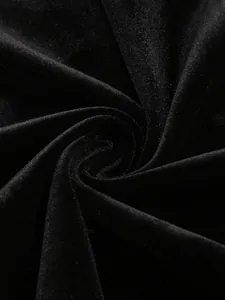 Vue macro montrant la texture douce et l'éclat du tissu en velours noir de la robe de soirée