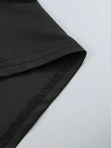 Detailed close-up of the hemline and stitching on a black ruched long sleeve dress