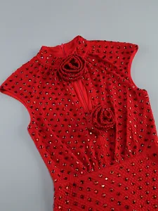 Detail view of a red evening dress featuring intricate rhinestones and 3D floral appliqués.