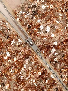 Detailed view of shimmering golden sequins and high-quality silver zipper on a party dress