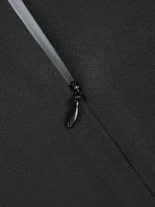 Close-up of the smooth invisible zipper detail on the back of a black evening gown.