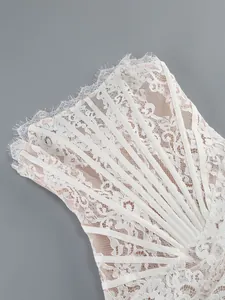 Close-up detail of white floral lace bustier dress with eyelash trim and boning.