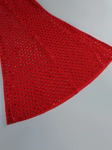 Detailed view of red rhinestone embellishments on a long evening gown fabric