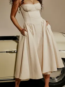 Elegant cream corset midi dress with flared skirt and pockets next to a vintage car