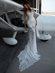 Elegant white strapless lace corset wedding gown with long sheer train at airfield