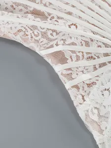 Detailed view of elegant white lace dress with sheer mesh and structural boning