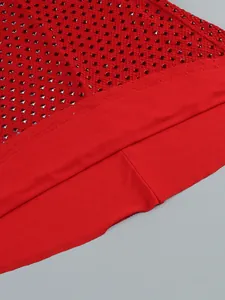 Macro detail of red rhinestone embellishments on an elegant evening dress fabric hem