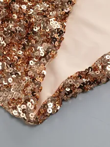 Close-up detail of shimmering gold sequins on high-end evening dress luxury fabric