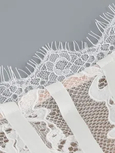 High-quality close-up of delicate white eyelash lace and mesh detail on a formal dress