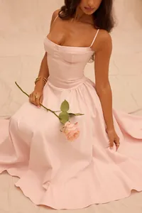 Elegant pale pink corset spaghetti strap evening gown with a flowing skirt and rose prop