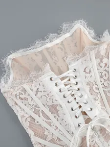 Close-up of white eyelash lace corset dress with satin ribbon lacing detail.