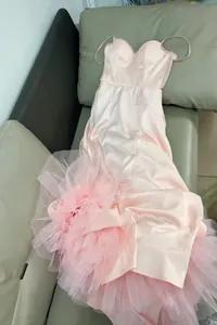 Detailed view of pink satin evening dress with voluminous ruffled tulle mesh skirt