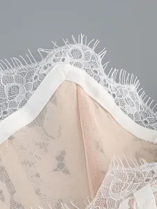 Detail shot showing delicate white eyelash lace trim and fine stitching on mesh fabric