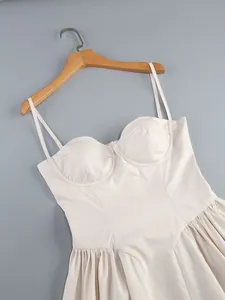 Detail view of the bustier top and delicate straps on a cream evening camisole dress
