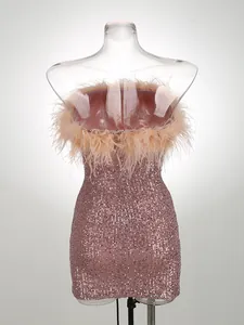 Vista detallada de minivestido rosa de lentejuelas con plumas de avestruz en maniquí