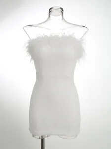 Primer plano de vestido blanco de lentejuelas con elegante borde de pluma avestruz.