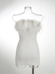 Primer plano de vestido palabra de honor blanco con lentejuelas y plumas de avestruz