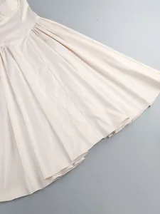 Detailed macro view of cream white banquet evening dress skirt showing fabric drape