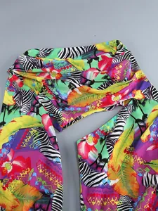 Detailed view of the vibrant tropical floral and zebra print on a one-shoulder dress