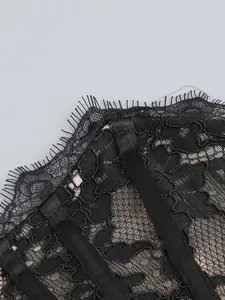 Close-up of black eyelash lace and satin ribbon detailing on elegant evening gown