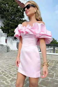 Detalle de un vestido de noche rosa con volantes y diseño con hombros descubiertos