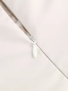 Close-up detail of a smooth invisible zipper on an elegant beige party dress fabric