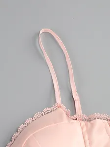 Detail shot of delicate lace trim and thin adjustable strap on a pink elegant evening dress