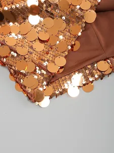 Vista de primer plano de grandes lentejuelas metálicas de bronce en un vestido de noche