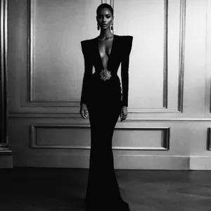 Close-up full view of black evening gown with plunging neckline and structured pads.