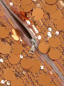 Detalle macro de lentejuelas de oro rosa brillante y cremallera metálica en vestido de gala