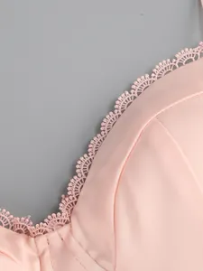 Close-up detail of pink satin dress bodice featuring delicate lace trim edging.