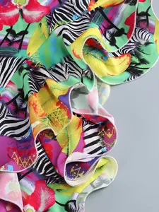 Detailed macro view showing the vibrant tropical print and ruffled hem of this summer party dress