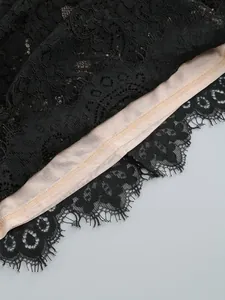 Close-up detail of black eyelash lace hem with nude lining for a luxury dress