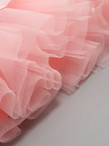 Close-up view of elegant pink layered tulle mesh fabric for high-end formal dress details