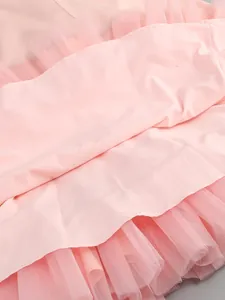 Detail shot of pink tulle dress hem showing layered mesh and smooth fabric lining