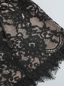 Detail shot showing intricate black floral lace texture with delicate eyelash trim.