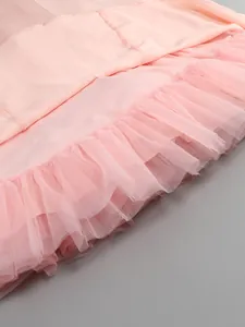 Macro view showing the intricate layered pink tulle ruffles on an elegant dress hem.