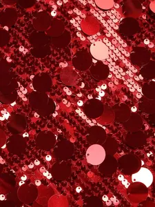 Vista macro de lentejuelas rojas redondas y brillantes en tela de vestido de noche de lujo