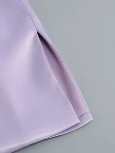 Vista detallada de la elegante tela de satén púrpura y la abertura de un vestido