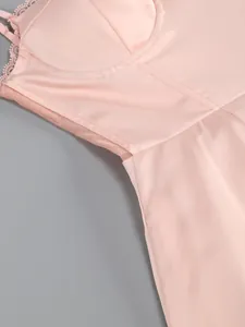 Macro view of a pink satin party dress featuring delicate lace trim and mesh waist details
