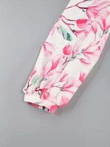Close-up of lantern sleeve cuff with pink floral magnolia print on white fabric