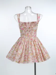 Back detail of a pink floral camisole dress featuring a smocked bodice and puff hem.