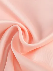 Macro detail of high-quality pink satin fabric showing its soft silk texture and luster