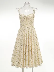Detail shot of a floral print midi dress with thin straps and tie-front detail.