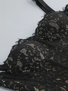 Close-up of the intricate black floral lace texture and mesh of the elegant dress