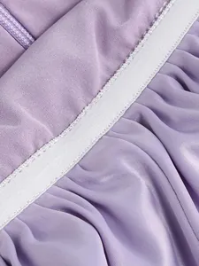 Detalle de cerca de la textura de volantes y la banda elástica blanca en el vestido morado