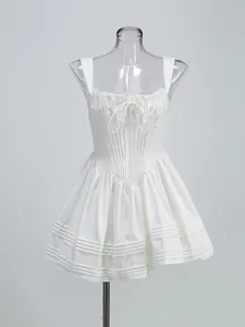 Detailed view of white corset mini dress featuring gathered bust and bow on mannequin